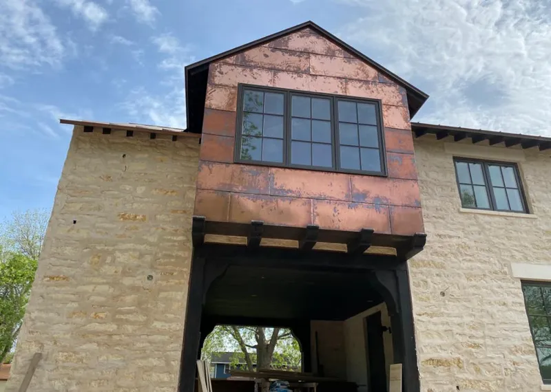 Copper metal panel facade on a stone building for Skylight Installation in Raymondville